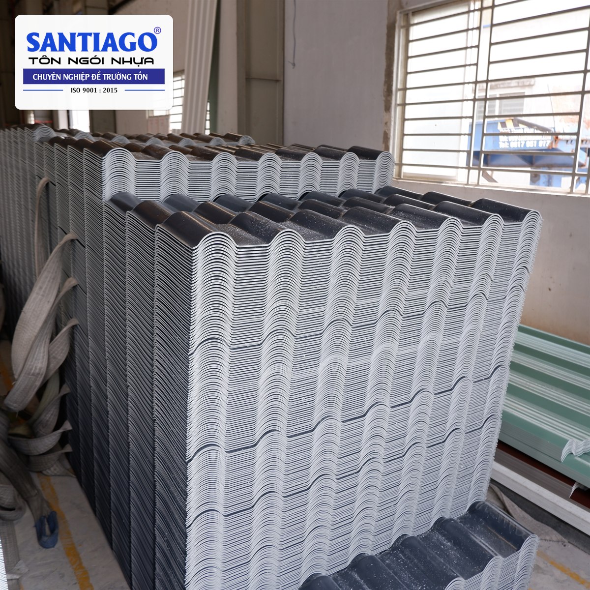 Các kiện tôn nhựa màu xám xếp trong kho nhà máy
