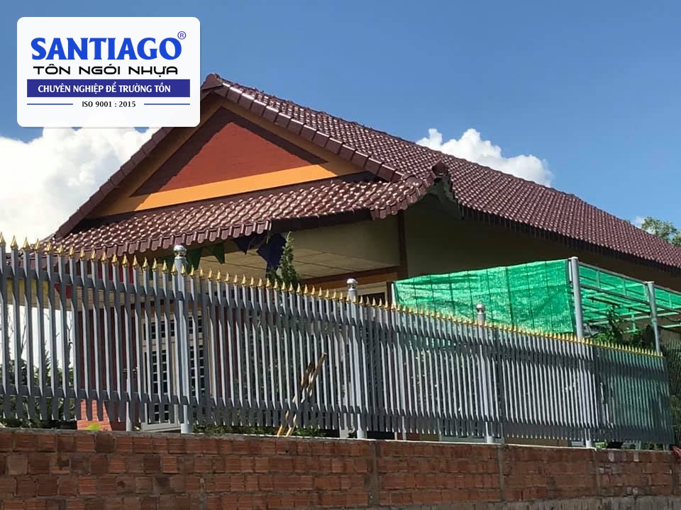 Nhà mái ngói nhựa đỏ đô có hàng rào trắng