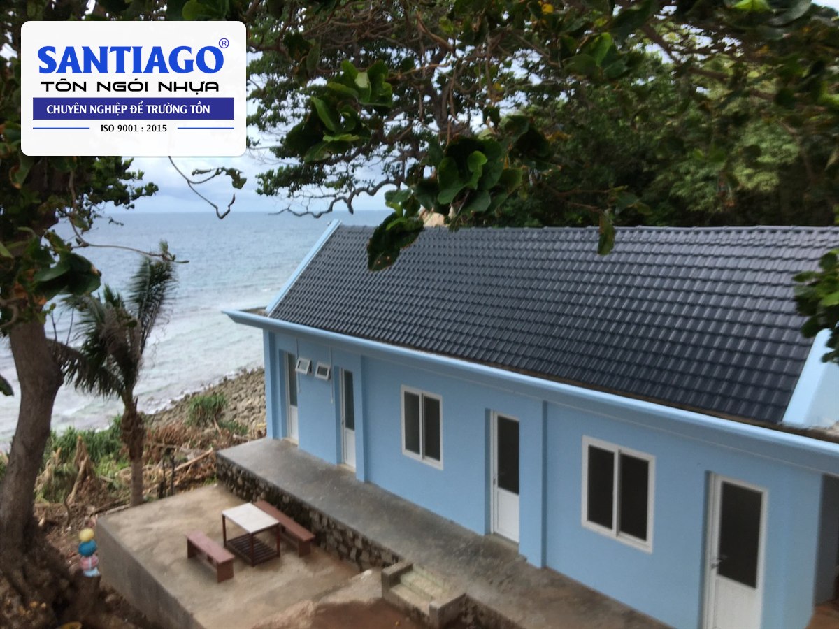 Ngôi nhà tường xanh mái ngói nhựa xám bên bờ biển