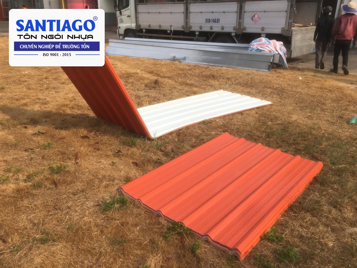 Tấm nhấn vòm tôn nhựa màu cam đặt trên bãi cỏ trước khi lợp