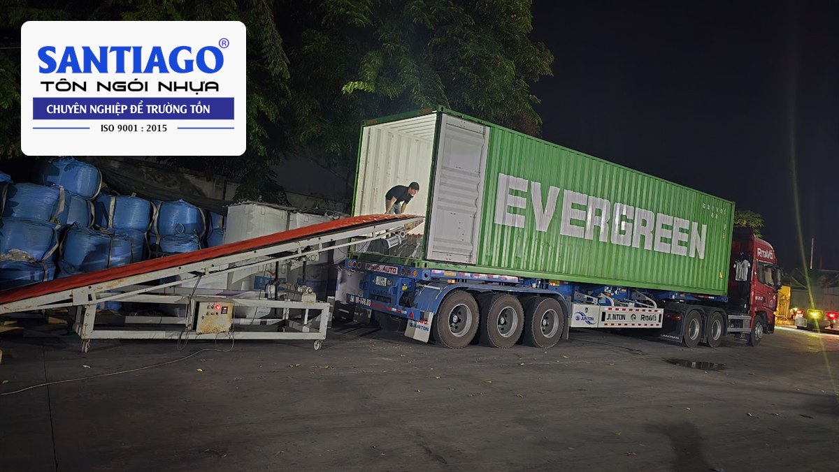 Xe nâng đưa kiện tôn ngói nhựa lên container ban đêm